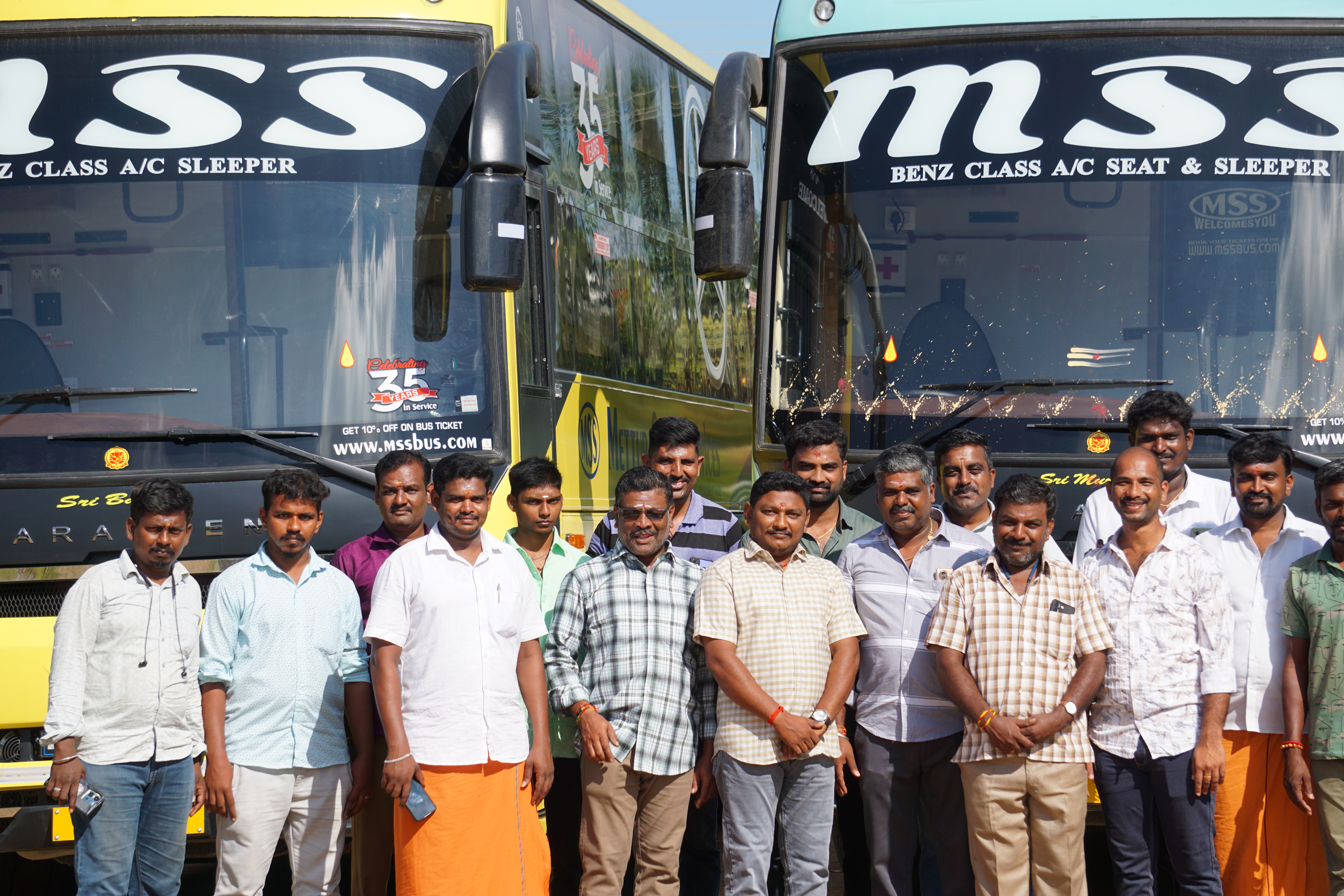 MSS team standing in front of Mettur Super Services omni buses